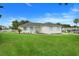 Charming single-story home with a well-manicured lawn, and light blue shutters and front door at 15629 Catherine Cir, Groveland, FL 34736