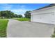 Attached garage with a smooth concrete driveway in front of a well-manicured lawn at 15629 Catherine Cir, Groveland, FL 34736
