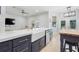 Kitchen area featuring blue cabinets, island, sink, and stainless steel dishwasher at 15629 Catherine Cir, Groveland, FL 34736