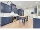 Kitchen showcasing blue cabinets, stainless steel appliances, island, and subway tile at 15629 Catherine Cir, Groveland, FL 34736