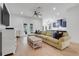 Open concept living room featuring a large sofa, hardwood floors, and view of the kitchen at 15629 Catherine Cir, Groveland, FL 34736