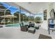 Cozy screened-in patio with comfortable seating, ceiling fan, and a view of the pool at 15629 Catherine Cir, Groveland, FL 34736