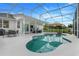 Backyard view featuring the screened in pool, patio furniture, and manicured lawn at 15629 Catherine Cir, Groveland, FL 34736