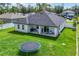 View of the home's back patio, lawn, and trampoline, enclosed by a white fence at 1620 6Th Ave, Deland, FL 32724