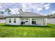 Backyard with a well-manicured lawn and a covered patio perfect for outdoor entertaining at 1620 6Th Ave, Deland, FL 32724