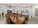 Open concept dining room and kitchen features long table with seating, white cabinets, and stainless appliances at 1620 6Th Ave, Deland, FL 32724