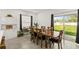 Dining room features long table with seating, modern light fixtures, and sliding glass doors to outside at 1620 6Th Ave, Deland, FL 32724