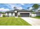 Beautiful single-story home featuring a lush green lawn, two-car garage, and modern architectural details at 1620 6Th Ave, Deland, FL 32724