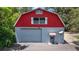Unique red and gray barn with a large garage door, awning, and a satellite dish, perfect for storage at 16318, 16250 & 16300 County Road 448, Mount Dora, FL 32757