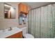 Functional bathroom with a single sink, shower with patterned curtain, and storage cabinet at 16318, 16250 & 16300 County Road 448, Mount Dora, FL 32757