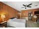 Cozy bedroom featuring wood paneled walls, a ceiling fan, and ensuite bathroom access at 16318, 16250 & 16300 County Road 448, Mount Dora, FL 32757
