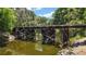 A rustic wooden bridge over a tranquil stream surrounded by lush greenery at 16318, 16250 & 16300 County Road 448, Mount Dora, FL 32757