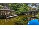 Picturesque waterfront property featuring a covered boat dock, scenic bridge, and serene water reflections at 16318, 16250 & 16300 County Road 448, Mount Dora, FL 32757