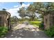 Grand entrance with brick pillars, an ornate iron gate, and a long driveway leading to a beautiful property at 16318, 16250 & 16300 County Road 448, Mount Dora, FL 32757