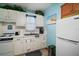 Efficient kitchen with white cabinetry, complete with a stove, refrigerator, and ample counter space at 16318, 16250 & 16300 County Road 448, Mount Dora, FL 32757