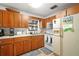 Traditional kitchen with wood cabinets, white appliances, and a view from the window at 16318, 16250 & 16300 County Road 448, Mount Dora, FL 32757