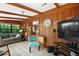 A view of the living room with a large television, wood paneling, and tiled floor at 16318, 16250 & 16300 County Road 448, Mount Dora, FL 32757