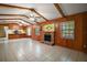 Spacious living room featuring wood paneling, a brick fireplace, and views of the kitchen at 16318, 16250 & 16300 County Road 448, Mount Dora, FL 32757