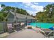 Inviting outdoor pool area with lounge chairs, a dining set, and a scenic view of the surrounding landscape at 16318, 16250 & 16300 County Road 448, Mount Dora, FL 32757