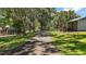 Landscape view of the property featuring a paved road, lush lawn and tree-lined surroundings at 16318, 16250 & 16300 County Road 448, Mount Dora, FL 32757