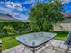 Outdoor patio features a table set on the patio, surrounded by a lush green lawn and landscaped garden at 1675 Westminster Ct, The Villages, FL 32162