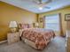 Bedroom featuring a window, floral bedding, and two side tables at 1675 Westminster Ct, The Villages, FL 32162
