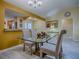 Open dining room with wood floors providing views into the kitchen at 1675 Westminster Ct, The Villages, FL 32162