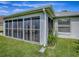Exterior view showing the screened in patio and backyard with a well-maintained lawn and garden at 1675 Westminster Ct, The Villages, FL 32162