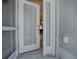 View of the home's front door with a decorative storm door and sidelights at 1675 Westminster Ct, The Villages, FL 32162