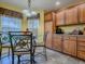The eat-in kitchen has ample light and features matching wooden cabinets and tile floor at 1675 Westminster Ct, The Villages, FL 32162
