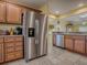 Well-lit kitchen featuring stainless steel appliances, wooden cabinets and a tile floor at 1675 Westminster Ct, The Villages, FL 32162