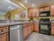Kitchen featuring wood cabinets, tile flooring, and black appliances at 1675 Westminster Ct, The Villages, FL 32162