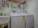 Well-equipped laundry room with modern washer and dryer, sink, and shelving for storage at 1675 Westminster Ct, The Villages, FL 32162