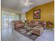Spacious living room with wood floors, comfortable seating and a sliding glass door at 1675 Westminster Ct, The Villages, FL 32162