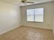 Bright bedroom featuring neutral walls, tile floors, a ceiling fan, and a window for natural light at 17483 Se 74Th Netherclift Ter, The Villages, FL 32162