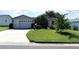 Charming single-story home with well-maintained lawn, mature trees, and a two-car garage at 17483 Se 74Th Netherclift Ter, The Villages, FL 32162