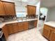 A well-lit kitchen features wooden cabinets, neutral countertops, and stainless steel appliances at 17483 Se 74Th Netherclift Ter, The Villages, FL 32162