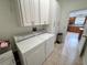Laundry room featuring white appliances, ample storage, and tiled flooring at 17483 Se 74Th Netherclift Ter, The Villages, FL 32162