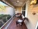 Enclosed porch features tiled flooring, a ceiling fan, and cozy seating, perfect for relaxing at 17483 Se 74Th Netherclift Ter, The Villages, FL 32162