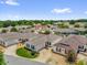 Aerial view showcasing a neighborhood of well-maintained homes with mature landscaping and clear blue skies at 17695 Se 84Th Peyton Ct, The Villages, FL 32162