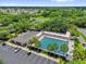 Aerial shot of a community pool surrounded by palm trees, with lounge chairs and parking at 17695 Se 84Th Peyton Ct, The Villages, FL 32162