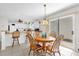 Cozy dining area adjacent to the kitchen, featuring a wooden table and chairs under an elegant light fixture at 17695 Se 84Th Peyton Ct, The Villages, FL 32162