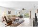 Bright living room featuring tile floors, comfortable seating, and a sliding glass door leading to an outdoor patio at 17695 Se 84Th Peyton Ct, The Villages, FL 32162