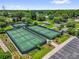 Aerial view of the pickleball courts in the community, with manicured landscaping, adjacent to a parking lot and green space at 17695 Se 84Th Peyton Ct, The Villages, FL 32162