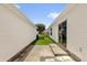 Side yard between houses featuring a walkway and lawn at 17695 Se 84Th Peyton Ct, The Villages, FL 32162