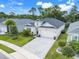 Well maintained single-story home features a two-car garage, manicured lawn and gray brick driveway at 1990 Wallingford Loop, Mount Dora, FL 32757