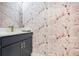 Powder room featuring flamingo wallpaper, marble countertops, and modern fixtures at 1990 Wallingford Loop, Mount Dora, FL 32757
