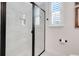 Bright bathroom featuring a black-framed glass shower and tiled walls at 1990 Wallingford Loop, Mount Dora, FL 32757