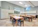 Brightly lit craft room with tables, chairs, and ample storage at 1990 Wallingford Loop, Mount Dora, FL 32757