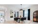 Inviting dining area with stylish light fixture, dark table with seating, and large mirrors at 1990 Wallingford Loop, Mount Dora, FL 32757